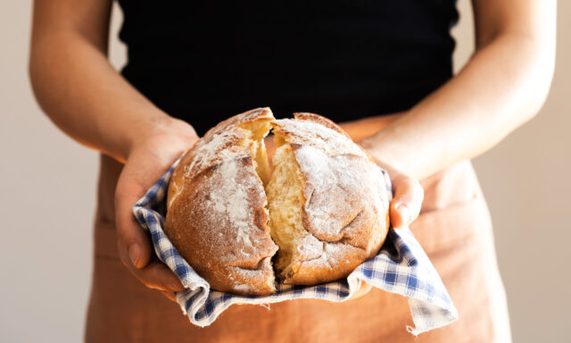 Female hand holding hot freshly baked bread
